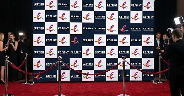 Photograph of three blank framed fabric display panels and a banner stand under spotlights in an empty convention foyer.