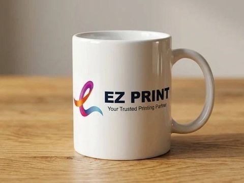 A luxury glossy white ceramic mug with sublimated EZ Print ribbon mark on an oak table.