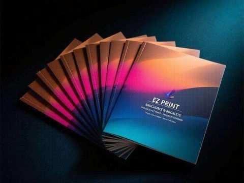 A fan of printed leaflets in magenta, amber and blue gradients.